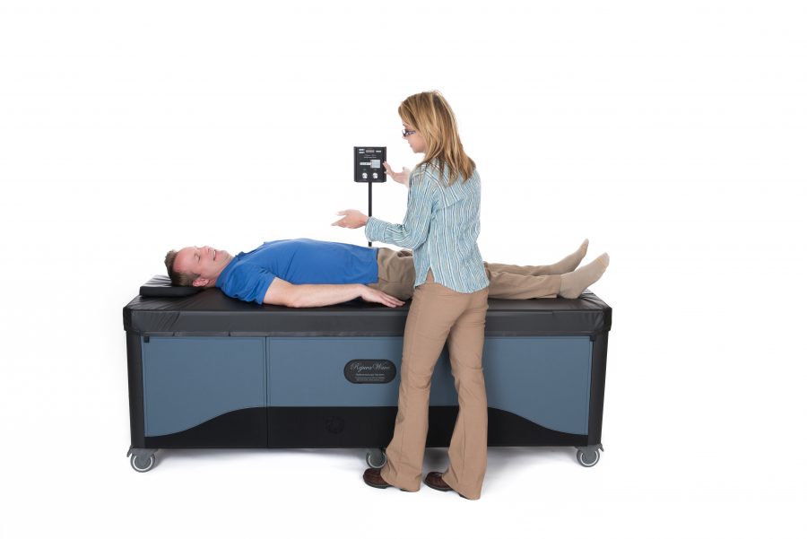 doctor putting patient on full body hydromassage table